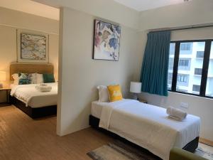 a hotel room with two beds and a window at Urban Living Residence in Kuala Lumpur