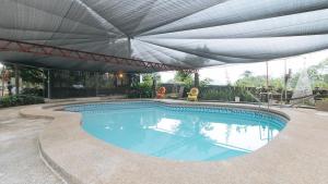 a swimming pool with an umbrella over it at RedDoorz @ Cristina's Hideaway Resort Tanay in Rizal