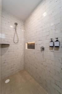 uma casa de banho com um chuveiro numa parede de tijolos brancos em Casa Blú Huatulco em Santa Cruz, Huatulco