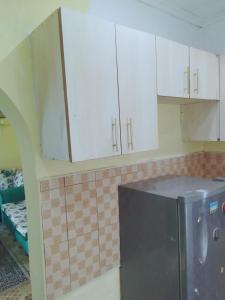 a kitchen with white cabinets and a refrigerator at BONNY KINGs FARMSTAY in Kiambu