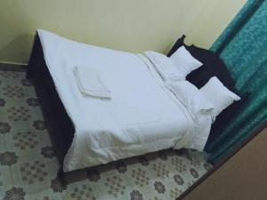 ein Bett mit schwarzen und weißen Kissen darauf in der Unterkunft BONNY KINGs FARMSTAY in Kiambu