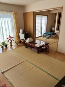a living room with a table and a mirror at GuestHouse MIYAZAKI for backpakers non smoker喫煙者不可 宮崎駅1Km in Miyazaki