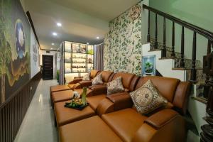 a living room with a brown leather couch at Silk Hanoi Moment Hotel & Spa in Hanoi
