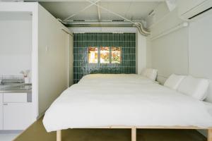 a bed in a room with a window at Asakusa 1976 in Tokyo