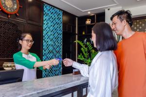 a woman is giving a man a ring at Wyndham Garden Hoi An Cua Dai Beach in Hoi An