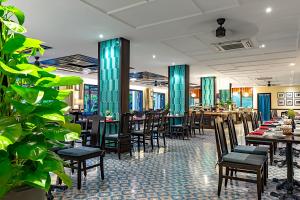 a dining room with tables and chairs in a restaurant at Wyndham Garden Hoi An Cua Dai Beach in Hoi An