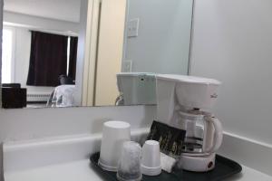 a coffee maker on a counter in front of a mirror at Midtown Inn in Saskatoon