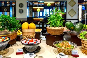 a buffet with fruits and vegetables in baskets on a table at Wyndham Garden Hoi An Cua Dai Beach in Hoi An
