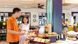 a man and a woman standing in front of a counter at Wyndham Garden Hoi An Cua Dai Beach in Hoi An