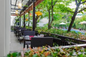 a row of tables and chairs in a restaurant at Wyndham Garden Hoi An Cua Dai Beach in Hoi An