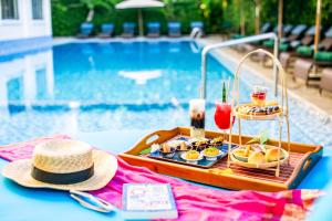 a tray of food on a table next to a pool at Wyndham Garden Hoi An Cua Dai Beach in Hoi An