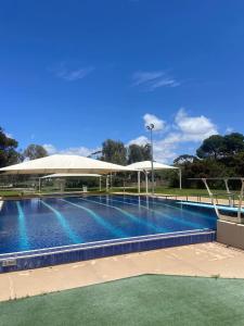 ein großer Pool mit einem großen weißen Sonnenschirm in der Unterkunft Flinders Ranges Motel - The Mill in Quorn