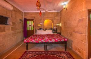 a bedroom with a bed in a stone wall at Hotel Oasis Haveli in Jaisalmer