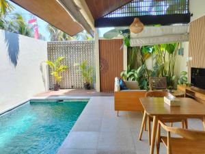 an indoor pool with a table and chairs and a dining room at Casalita Ubud Romantic Villas in Ubud
