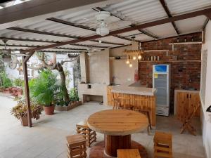 een buitenkeuken met een houten tafel en een eetkamer bij Casa al pie de la playa con Aire acondicionado y BBQ in Playas