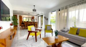 a living room with yellow chairs and a couch at The Grand Chalet in Jarabacoa
