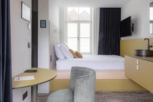 1 dormitorio con cama, mesa y ventana en Gare 55 en Evergem