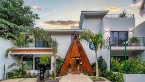 una casa con una puerta de madera y palmeras en Casa Blú Huatulco en Santa Cruz Huatulco