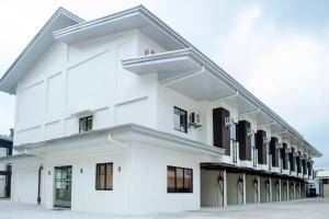 a white building with black windows at RedDoorz @ Washington Guest House Olongapo in Olongapo