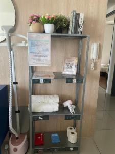 une étagère avec du papier toilette et des plantes sur elle dans l'établissement ❈ Tropicana 218 by ALV Suites ❈, à George Town