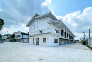 un edificio bianco con un parcheggio di fronte di RedDoorz @ Washington Guest House Olongapo a Olongapo