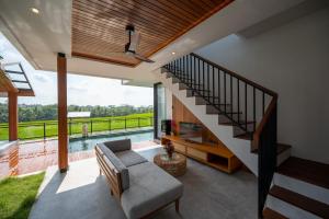 a living room with a staircase and a couch at Kairos Villa Ubud by Omkara Experience in Ubud +29 photos