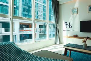 a living room with a couch and a large window at Homesuite' Home at Sutera Avenue in Kota Kinabalu