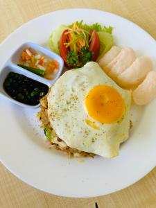 a plate of food with an egg and some vegetables at The Taman Ayu in Seminyak
