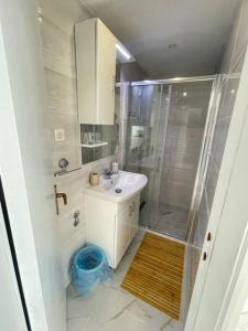 ein weißes Bad mit einer Dusche und einem Waschbecken in der Unterkunft Apartments Sea View - cosy & comfortable in Brist