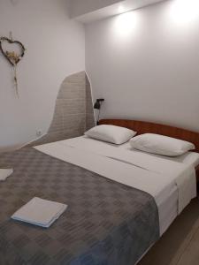 1 dormitorio con 1 cama grande con sábanas blancas en Apartments Ivana - free parking and 100m from the beach, en Trpanj