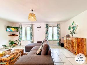 a living room with a couch and a table at Villa Ti Coin Frais - 100 m² - Plaine des Palmistes in La Plaine des Palmistes
