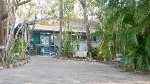 ein Haus mit Palmen davor in der Unterkunft Emeraldene Inn & Eco-Lodge in Hervey Bay