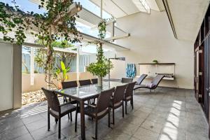 a dining room with a glass table and chairs at Bronze in Lennox Head