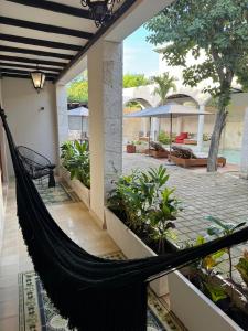 a hammock on the side of a house with a patio at Los Frailes Concept Hotel in Valladolid