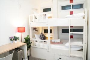 a white bunk bed in a room with a desk at Qilombo Hostel Silom - HQ in Bangkok