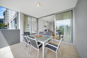 a dining room with a table and chairs at Trilogy Residences Brisbane in Brisbane