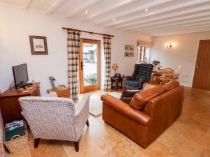 uma sala de estar com um sofá de couro e cadeiras em The Granary em Askham