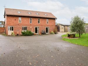 a brick house with a driveway in front of it at The Granary in Askham