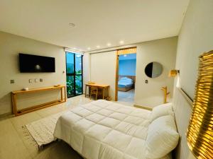 1 dormitorio con 1 cama blanca grande y TV en Casa Mosso, 3 rooms house and pool, en Oaxaca City
