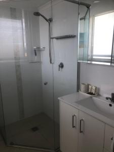 a bathroom with a glass shower and a sink at The Atrium Resort in Gold Coast