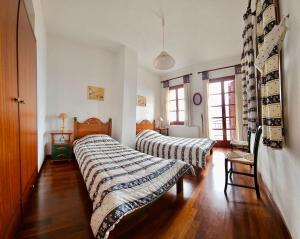 due letti in una stanza con pavimenti in legno di Duke's Horizon Villa in Arachova ad Aráchova
