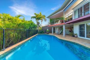 a swimming pool in front of a house at Lee Lane Beach House - Lighthouse Rd Byron in Byron Bay