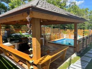 a wooden gazebo with a pool in a yard at The Grand Chalet in Jarabacoa