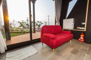 a red chair sitting in front of a large window at Peekaboo in Xiaoliuqiu