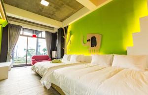 two beds in a room with a green wall at Peekaboo in Xiaoliuqiu