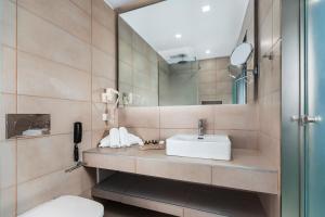 a bathroom with a sink and a mirror at The Aeolos Beach Hotel in Kos