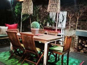 a wooden table and chairs with a cactus on a patio at Ons Huisie - No Loadshedding in Beaufort West