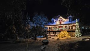 una casa decorada con luces de Navidad y un árbol de Navidad en Auberge La Châtelaine, en La Malbaie