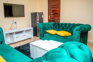 een woonkamer met een groene bank en een tv bij Cozy apartment kisii in Kisii