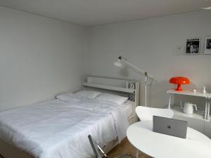 1 dormitorio con 1 cama y escritorio con ordenador portátil en M Stay Near Mokdong Station, en Seúl